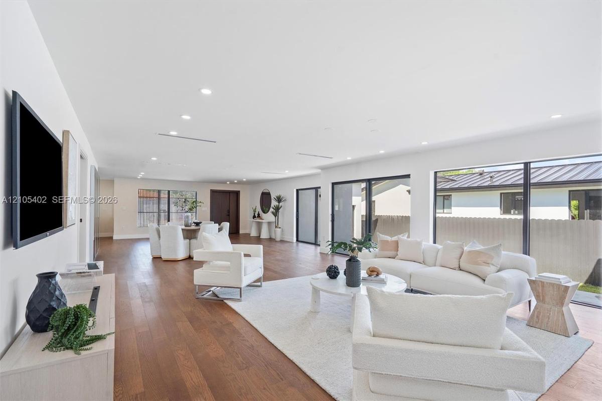 Open-concept interior featuring wood-finish flooring, recessed lighting, and large sliding glass doors