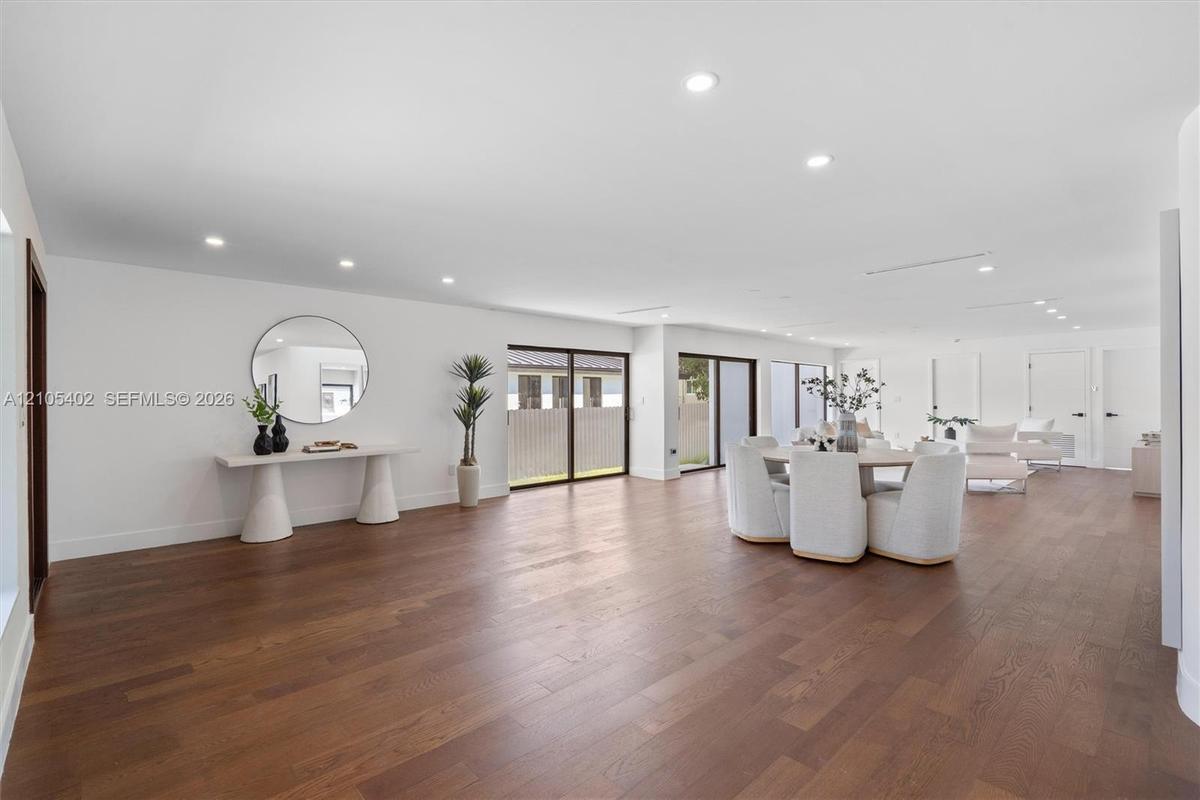Open-concept interior featuring wood-finish flooring, recessed lighting, and multiple sliding glass door sets