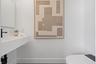 Wall-mounted floating sink with integrated basin, matte black faucet, and modern elongated toilet