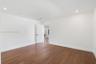 Interior room featuring wood-finish flooring, recessed lighting, and a white interior door with matte black hardware