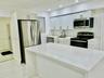 Kitchen featuring white shaker-style cabinetry, quartz countertops, a central island, stainless steel appliances, and recessed lighting