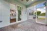 Screened-in patio featuring paver flooring, a ceiling fan, and sliding glass door access to the interior