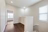 Neutral interior space featuring wood-finish flooring, recessed lighting, and a white handrail