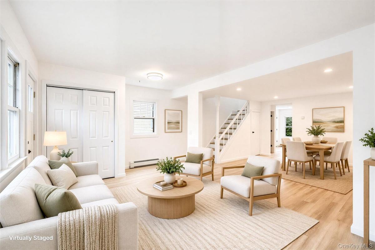 Open-concept interior featuring wood-finish flooring, recessed lighting, double-panel sliding closet doors, and a staircase with white balusters *virt