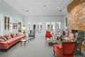 Living area featuring a floor-to-ceiling natural stone fireplace, vaulted ceilings, crown molding, recessed lighting, and multiple sets of glass-paned