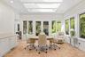 Sunroom featuring a vaulted ceiling with large skylights, tile flooring, built-in cabinetry with solid-surface countertop, and extensive multi-pane wi