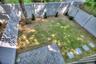 Rear yard featuring a full-height vinyl privacy fence, a grey stone paver patio, a manicured lawn, stone stepping stones, and mature trees