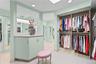 Custom dressing area featuring floor-to-ceiling built-in cabinetry, an integrated vanity with a stone countertop, recessed ceiling lighting, mirrored 