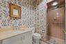 En suite bathroom featuring a solid-surface vanity countertop, undermount sink, built-in cabinetry, walk-in shower with tile surround and glass door, 