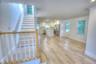 Open-concept interior featuring wood-finish flooring, recessed lighting, and a kitchen equipped with a center island and stainless steel appliances, a
