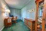 Interior space to left of front entry door featuring a multi-pane window, wall-to-wall carpeting currently used for a home office or could be a nice s