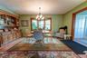 Dining area featuring a bay window with natural wood trim, custom moldings and hardwood floors.