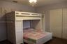 Double-door closet with paneled trim, wood-finish flooring, and a ceiling-mounted light fixture