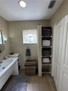 Bathroom featuring a vanity with an integrated sink, built-in wire shelving, wood-finish flooring, and a window with a sash lock