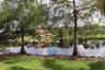Waterfront parcel featuring a natural pond, mature trees, and manicured landscaping