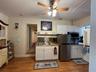 Kitchen featuring white shaker-style cabinetry, wood-finish countertops, a stainless steel undermount sink with a gooseneck faucet, stainless steel ap