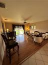Living area featuring wood-finish flooring, built-in wet bar, arched wall niches, sliding glass door, and a ceiling fan