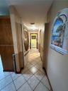 Ceramic tile flooring laid in a diagonal pattern, wood-finish interior doors, and neutral wall tones with decorative wall molding