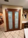 Double pantry doors featuring wood framing and decorative etched glass inserts with silver-tone hardware