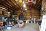 Spacious industrial-style workshop featuring high vaulted ceilings, exposed structural metal framing, reinforced concrete flooring, and extensive wall