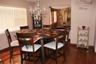 Dining area featuring wood-finish flooring, a multi-tiered crystal chandelier, and windows with horizontal blinds