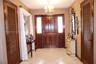 Foyer featuring a solid wood entry door with flanking sidelights, ceramic tile flooring, and dual wood-finished louvered closet doors