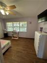Wood-finish flooring, multi-pane windows, and a multi-light ceiling fan with integrated illumination