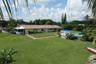 Expansive backyard featuring a large grass lawn, screened-in patio, and an above-ground swimming pool with a hardscape surround