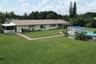 Expansive backyard featuring a manicured lawn, inground swimming pool with a pergola, screened-in porch, and concrete paver walkways