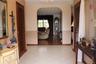 Foyer featuring light-toned tile flooring, a prominent arched entry, wood-finish flooring, and two wooden louvered doors