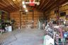 Expansive interior workshop featuring exposed structural steel framing, high vaulted ceilings with integrated lighting, concrete flooring, and plywood