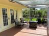 Screened-in porch featuring a tile floor, glass-paneled entry doors, and a transparent roof covering
