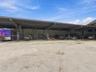 Expansive industrial structure featuring a metal-frame canopy, open-bay workspace, and concrete surface