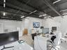Industrial-style room featuring an exposed black metal ceiling, linear LED lighting, wood-finish flooring, and built-in white cabinetry