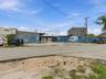 Industrial property featuring a paved asphalt exterior, fenced perimeter, and multi-story concrete structure
