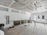 Industrial spray booth featuring insulated panel wall construction, integrated overhead lighting, dedicated air ventilation intake ports, and dual gla