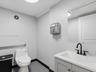 Restroom featuring a vanity with a white countertop, undermount sink, and matte black widespread faucet, paired with a frameless wall mirror, stainles