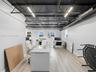 Industrial-style room featuring an exposed corrugated metal ceiling with dark steel trusses, linear LED lighting, and exposed circular ductwork, compl