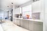 Kitchen featuring high-gloss cabinetry, stone-finish countertops, stainless steel appliances, patterned mosaic tile backsplash, and recessed lighting