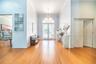 Entryway featuring wood-finish flooring, high ceilings, a crystal chandelier, arched transom window, and paneled doors