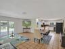Open-concept interior featuring ceramic tile flooring, white cabinetry, recessed lighting, and glass-paneled double doors