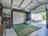 Detached metal workshop featuring an expansive interior, concrete flooring, exposed beam ceiling, and a large roll-up door