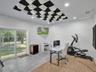 Interior space featuring wood-finish flooring, concrete flooring, sound-dampening ceiling panels, recessed lighting, and a sliding glass door