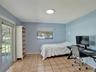 Room featuring tile flooring, a glass-paned door, a single-hung window with a roller shade, and a flush-mount overhead light fixture