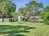 Expansive lot featuring mature trees, a metal-sided detached structure, and a fenced enclosure