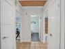 Ceramic tile flooring, white slab doors with modern lever hardware, and built-in shelving unit