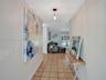 Entryway featuring ceramic tile flooring, neutral wall paint, and a geometric-style metal pendant light fixture