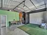Garage space featuring a vaulted ceiling with exposed metal structural elements, concrete flooring, and linear LED lighting