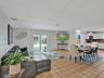 Open-concept interior featuring large-format tile flooring, French doors with glass panes, recessed lighting, and a sliding barn-style door