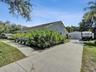 Single-story residence featuring a concrete driveway, detached garage with metal siding, and a paved walkway leading to the entrance